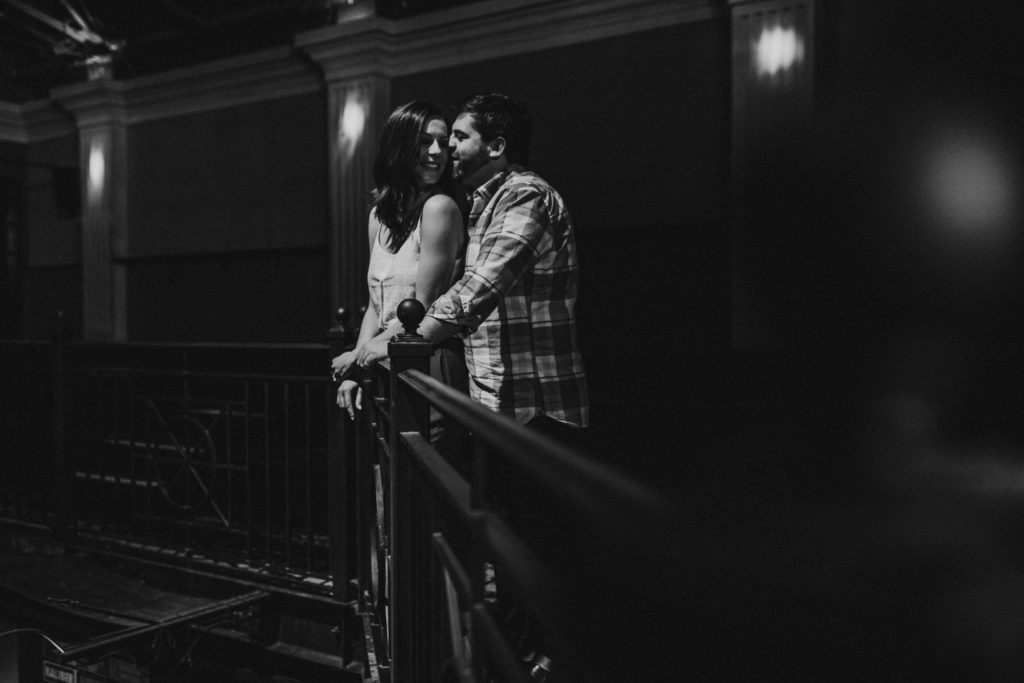 man and woman standing in the balcony at a concert