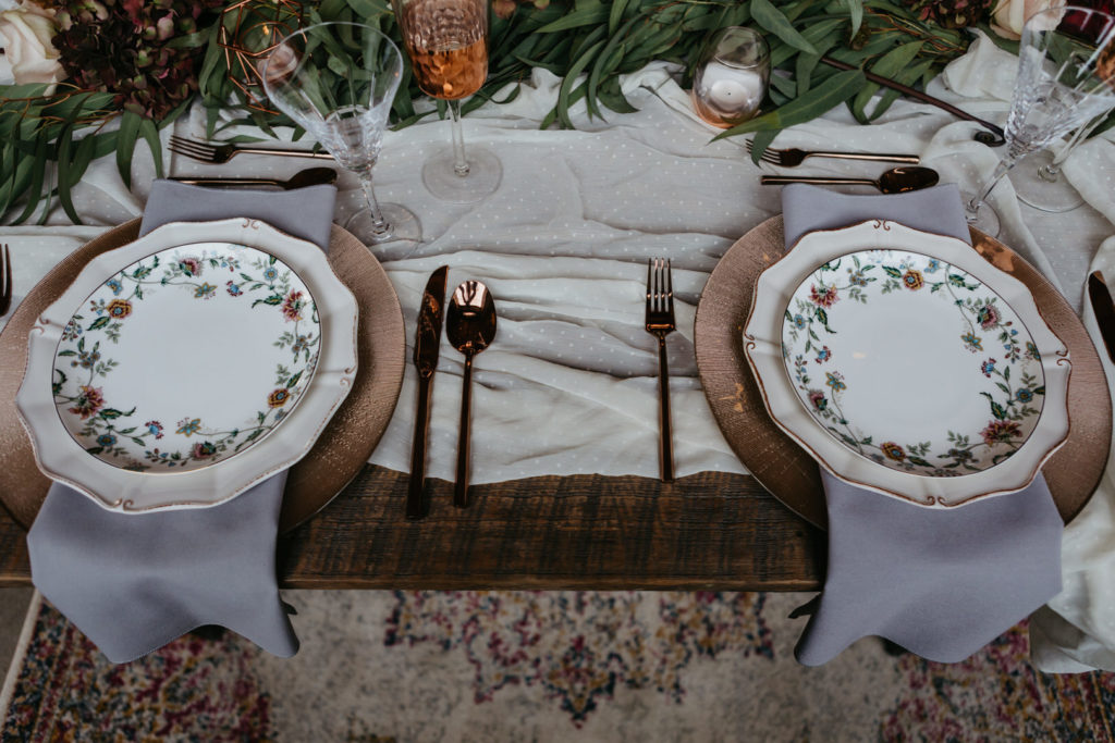 table setting with vintage floral china and purple napkins