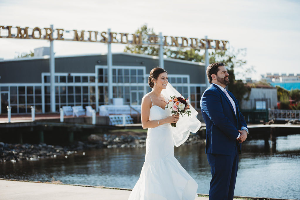 a bride and groom stand in front of the baltimore museum of industry